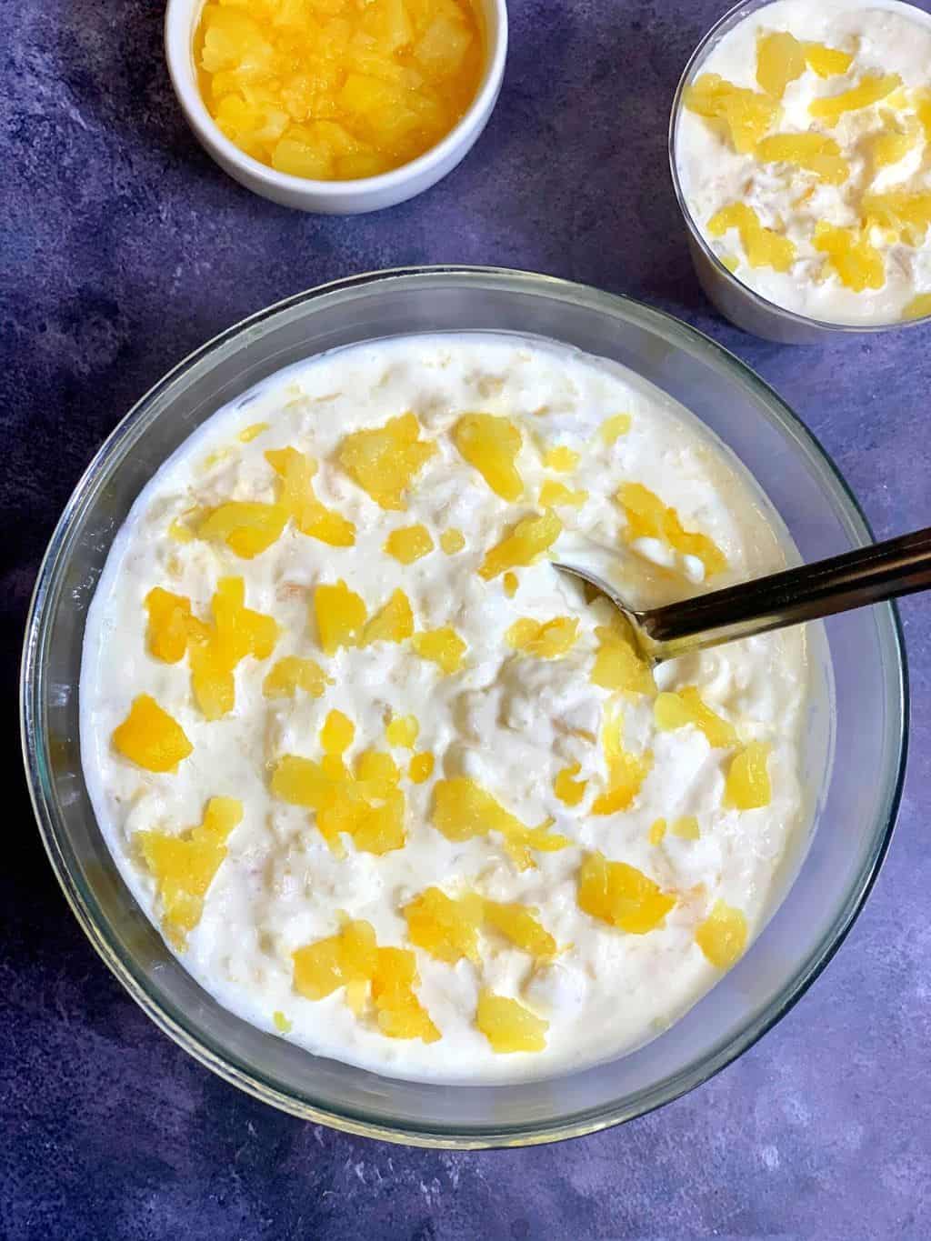 5 Minute Pineapple Dessert served in a glass bowl with spoon on top and canned pineapple on the side