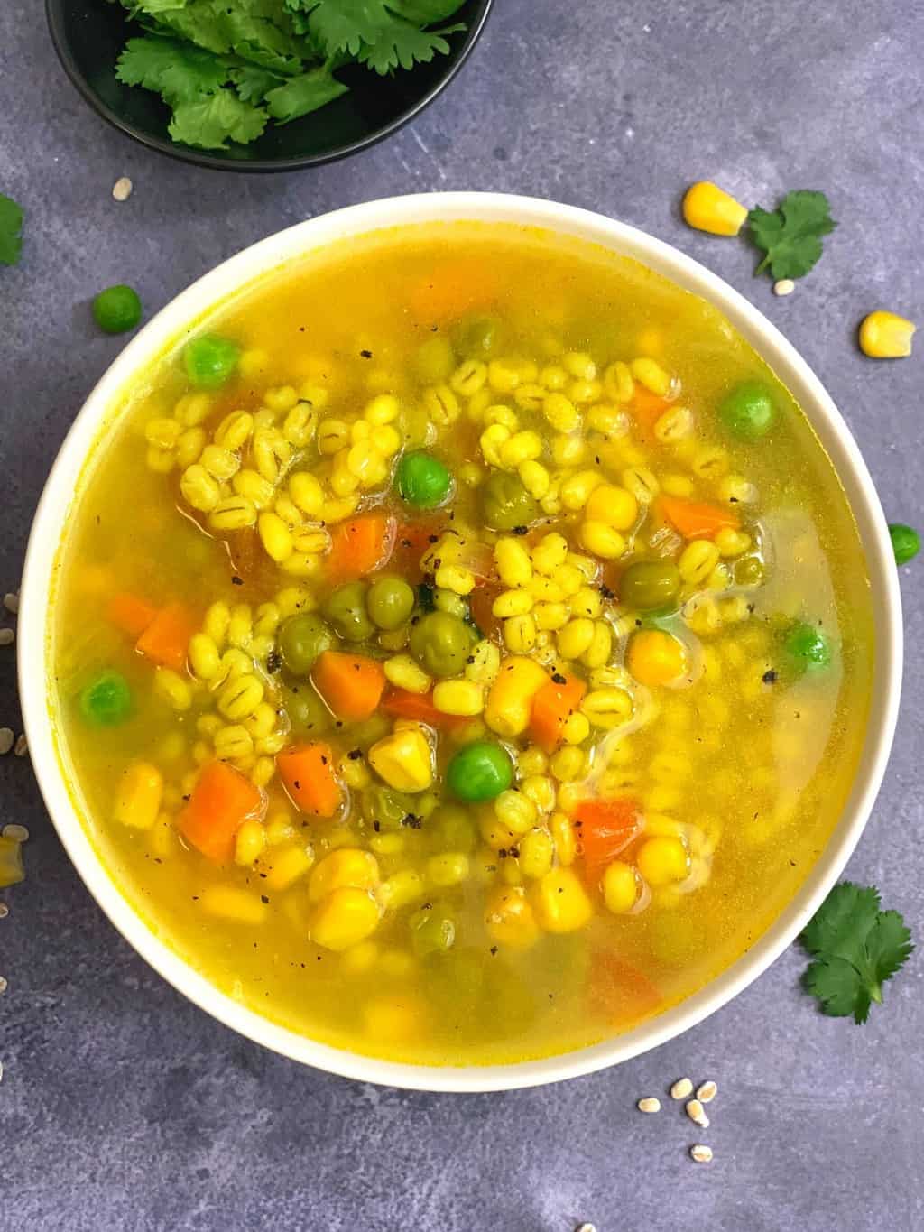 pearl barley soup served in a bowl garnished with cilantro