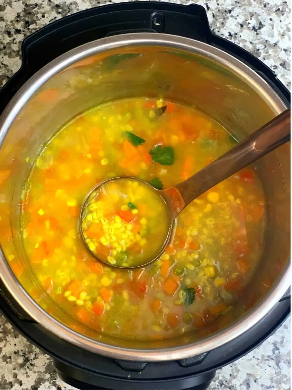 vegetable barley soup in instant pot insert with a spoon