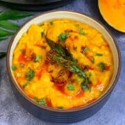 Butternut Squash Dal served in a bowl topped with tempering and a piece of butternut squash on the side