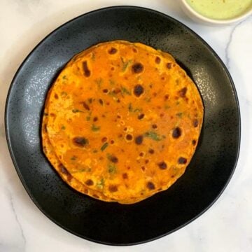 butternut squash paratha served on a plate with mint raita on the side