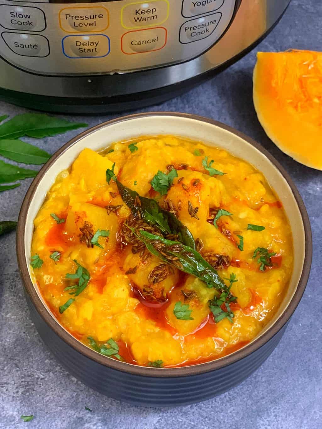 squash lentils served in a bowl with tempering on top and butternut squash piece on the side along with instant pot