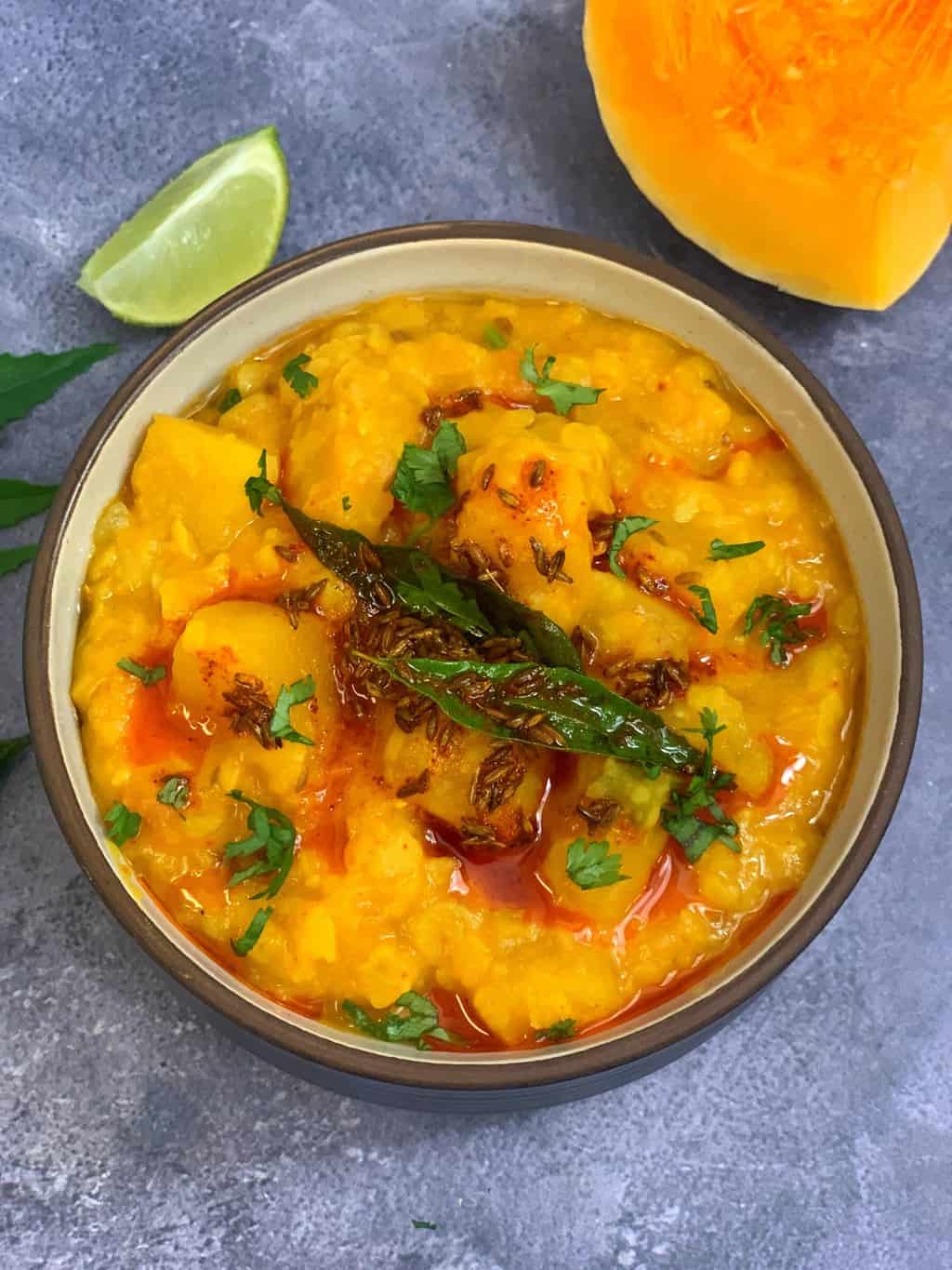 instant pot butternut squash dal in a bowl with lemon wedge on side and piece of squash