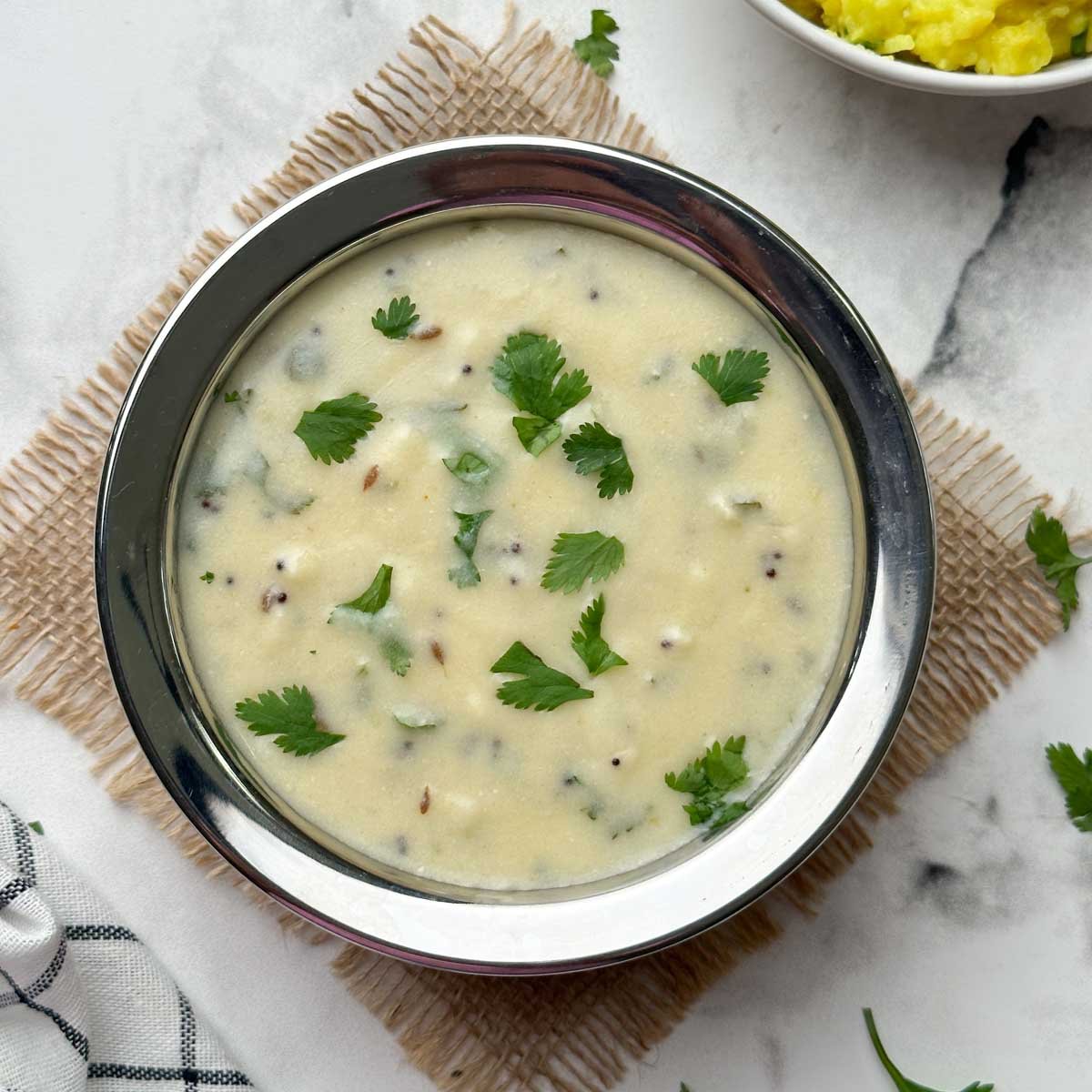 gujarati kadhi served in a bowl and khichdi on the side