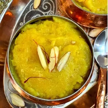 badam halwa com farinha de amêndoas servido em uma tigela decorado com lascas de amêndoas e fios de açafrão