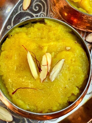 badam halwa with almond flour served in a bowl garnished with slivered almonds and saffron strands