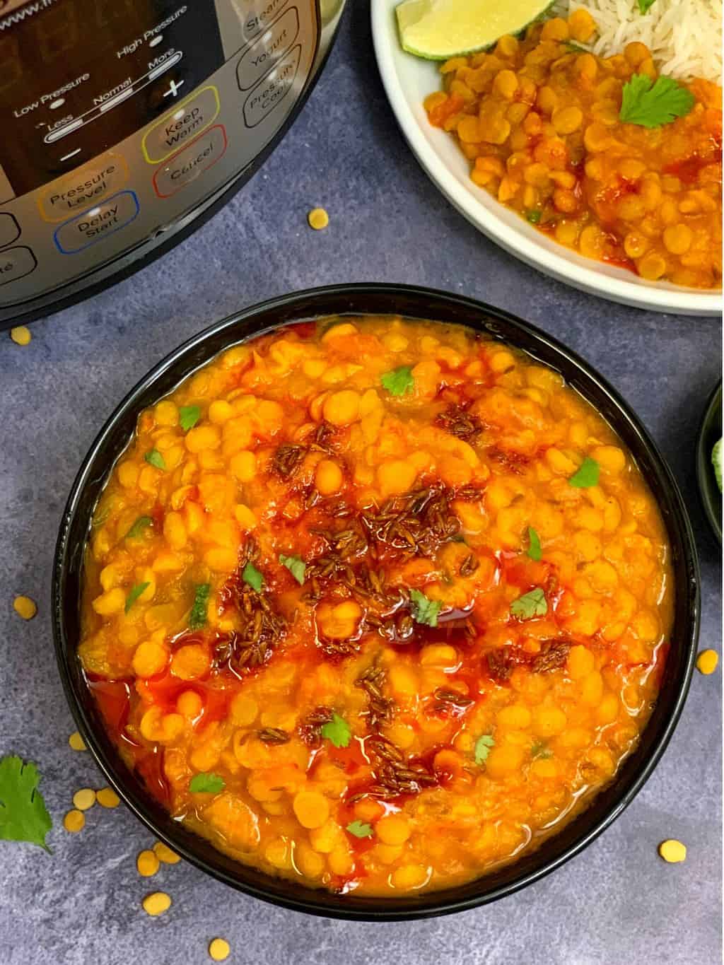 chana dal served in a bowl with tempering on top with side a rice