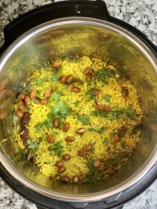 lemon rice in instant pot insert garnished with cilantro and roasted peanuts