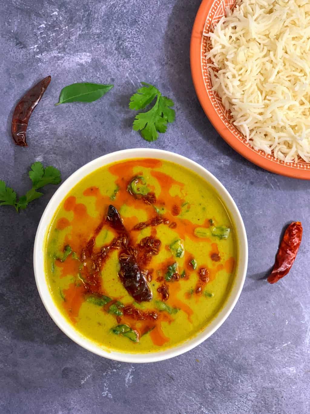 yogurt soup served in a bowl with ghee tempering on the top and side of plain basmati rice