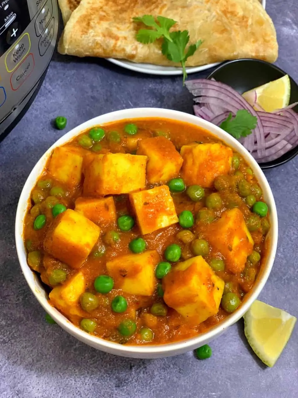 instant pot matar paneer served in a bowl with paratha and lemon wedge on the side along with instant pot