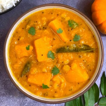Pumpkin Sambar made of lentils and pumpkin served in a bowl with cooked rice on side
