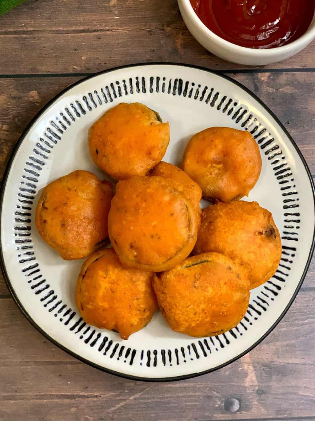 Zucchini Bajji served in a plate with tomato ketchup on the side