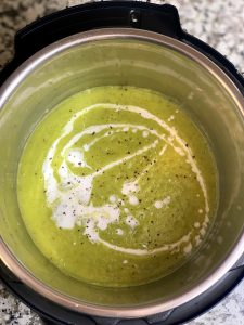 cream of zucchini soup in the instant pot insert topped with coconut milk