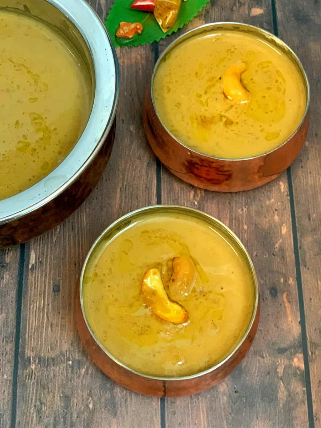 chana dal payasam served in two bowls garnished with roasted cashews