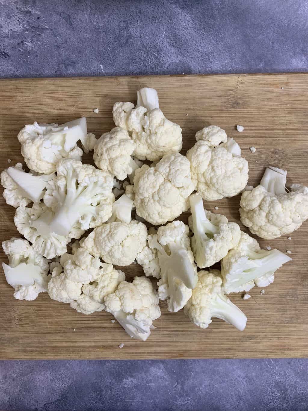 cauliflower florets on the wooden cutting board