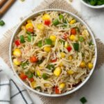 sweet corn fried rice served in a bowl with chop sticks and green onions on the side