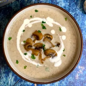 Cream of Mushroom Soup served in a bowl topped with sautéed mushrooms and cream