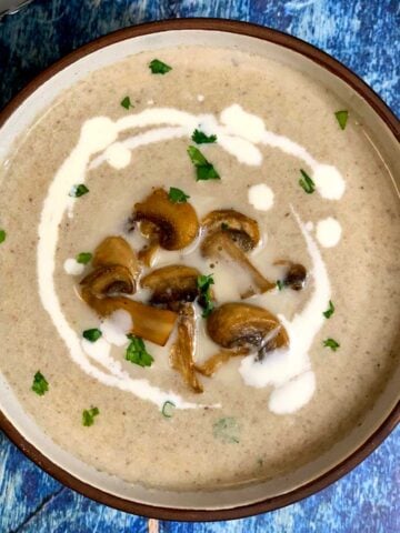 Cream of Mushroom Soup served in a bowl topped with sautéed mushrooms and cream