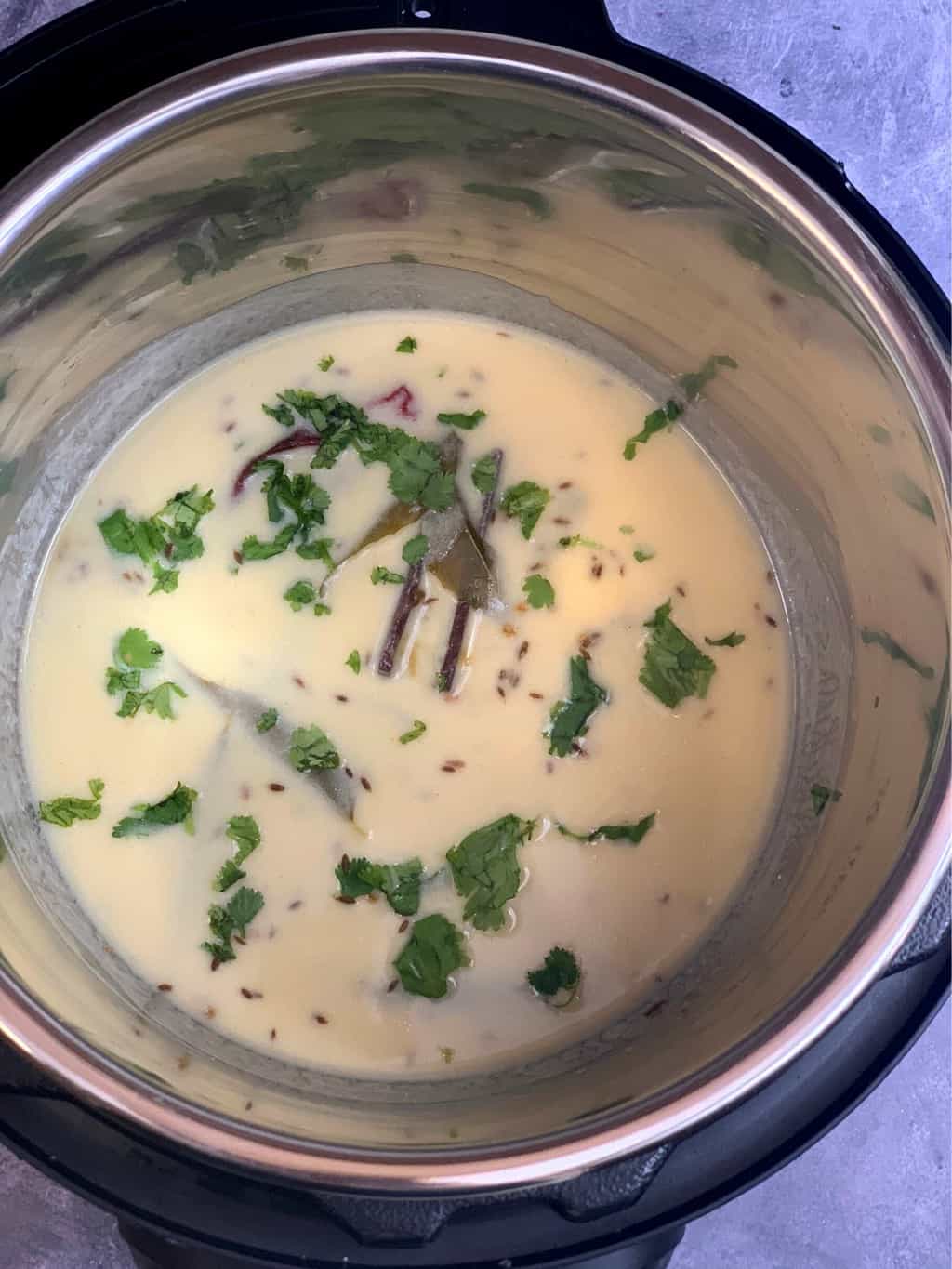 gujarathi kadhi in the instant pot steel insert garnished with coriander leaves