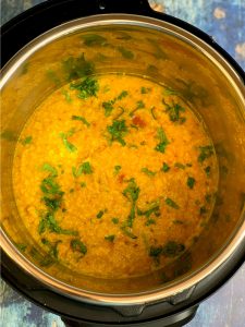 moong dal (yellow lentil soup) in the insert garnished with cilantro