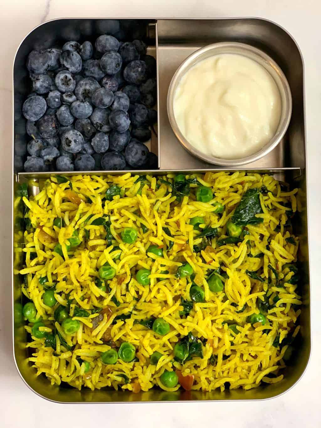 kids lunch box moringa rice ,yogurt and blueberries served in a steel bento box