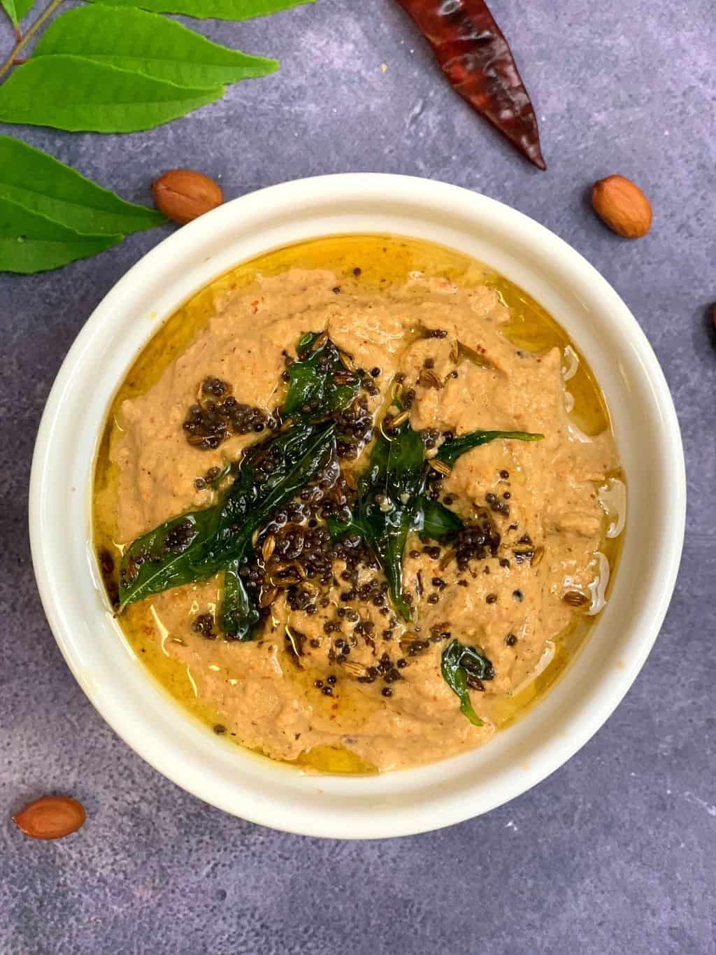 peanut chutney served in a bowl with tempering on the top
