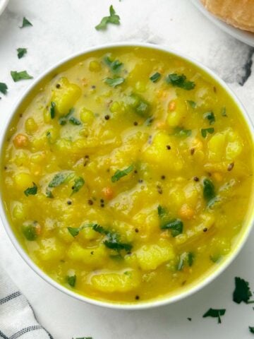 potato sagu served in a bowl with poori on the side