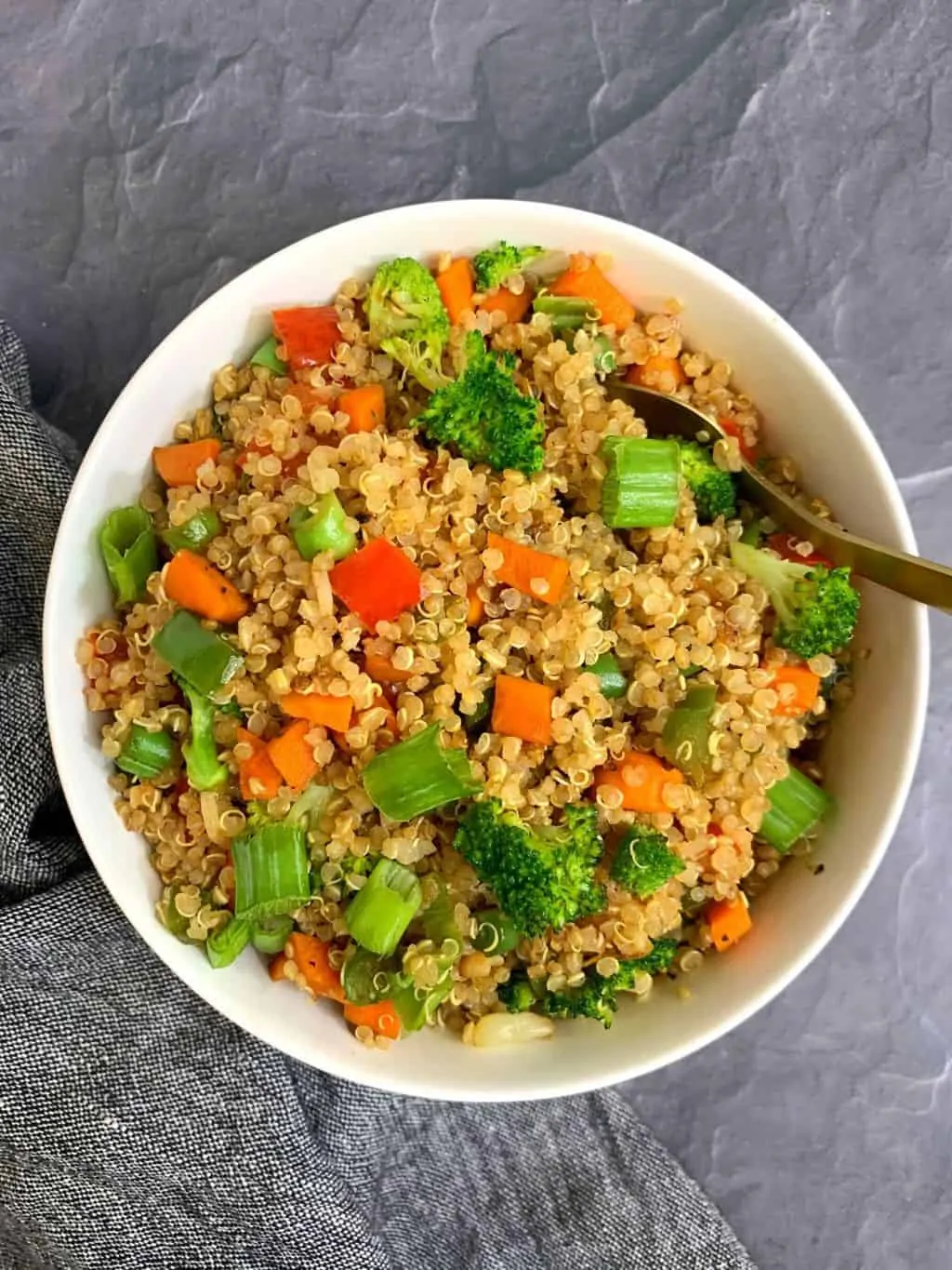 quinoa fried rice served in a bowl with a spoon