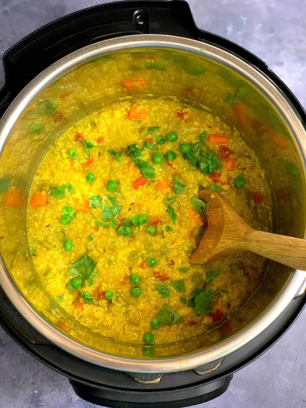 cooked quinoa khichdi in the instant pot insert garnished with coriander leaves