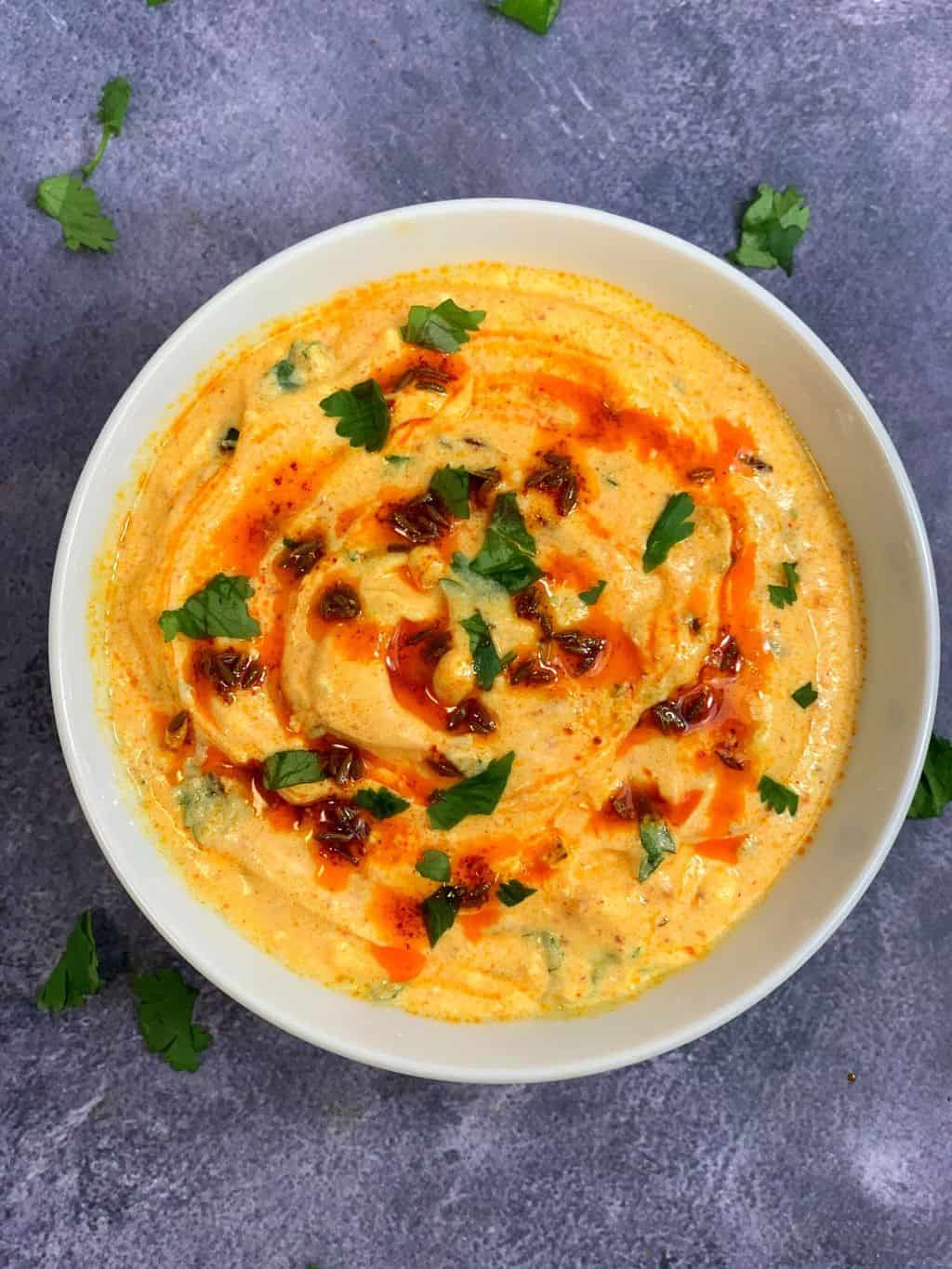 spiced Yogurt Curry served in a bowl with tempering on the top and garnished with cilantro