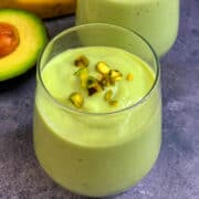 Avocado Banana Smoothie served in 2 glass servings topped with pistachios