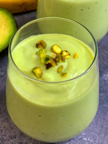 Avocado Banana Smoothie served in 2 glass servings topped with pistachios