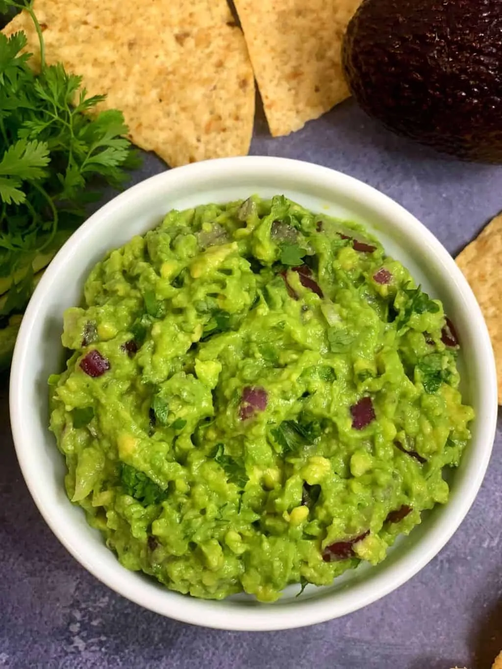 guacamole served in a bowl with chips on the side