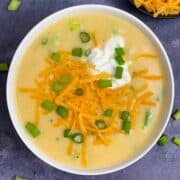 Potato Soup served in a bowl garnished with cheddar cheese and green onions