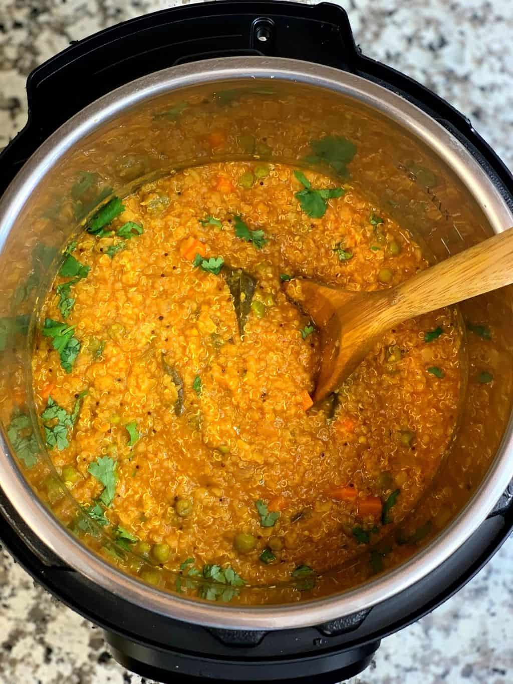 instant pot Quinoa bisi bele bath  garnished with cilantro in insert with a spoon