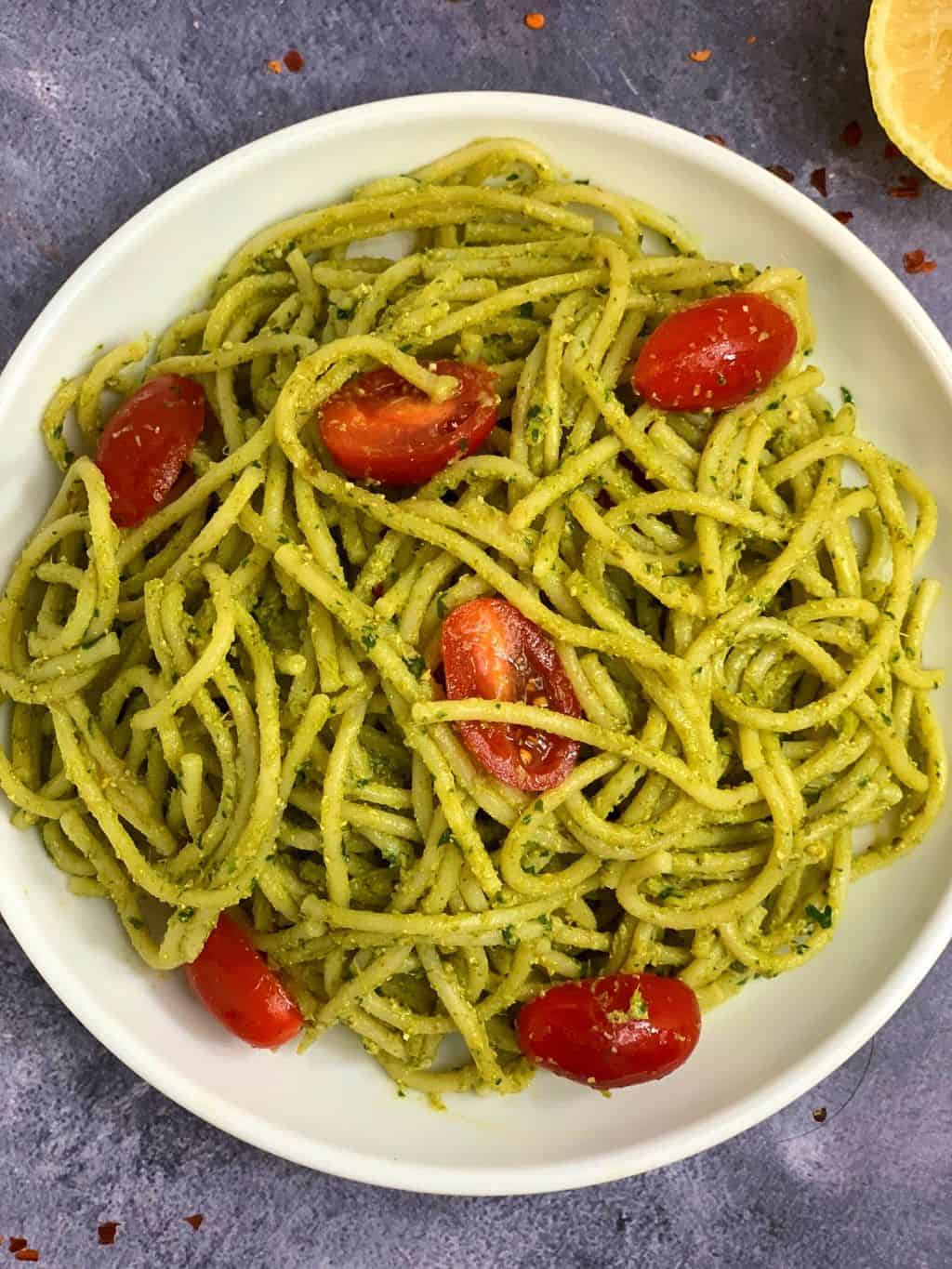 noodles served on a plate with cherry tomatoes on top