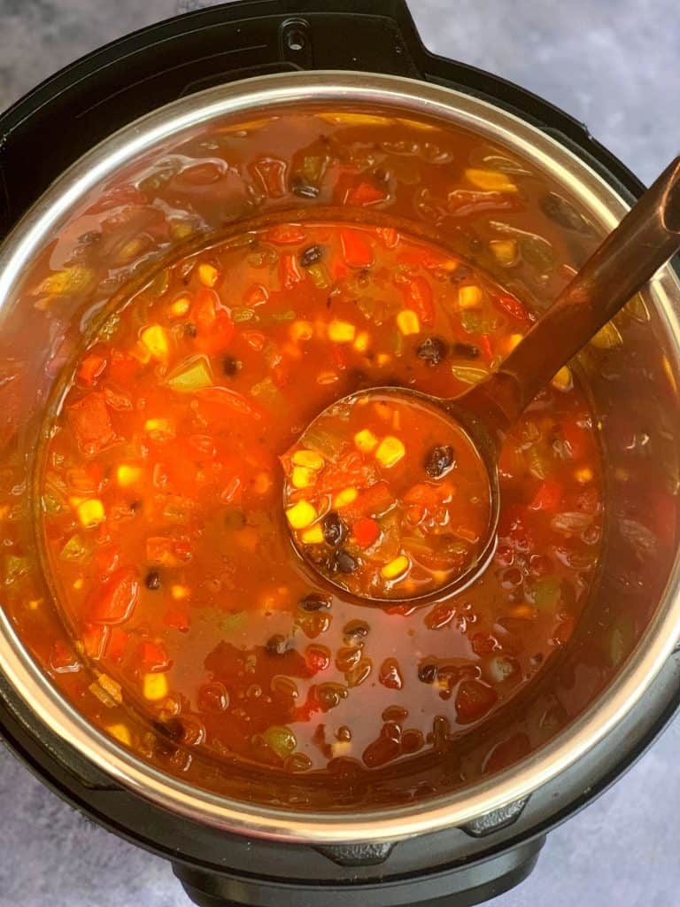 vegetarian taco bean soup in the instant pot insert with a spoon