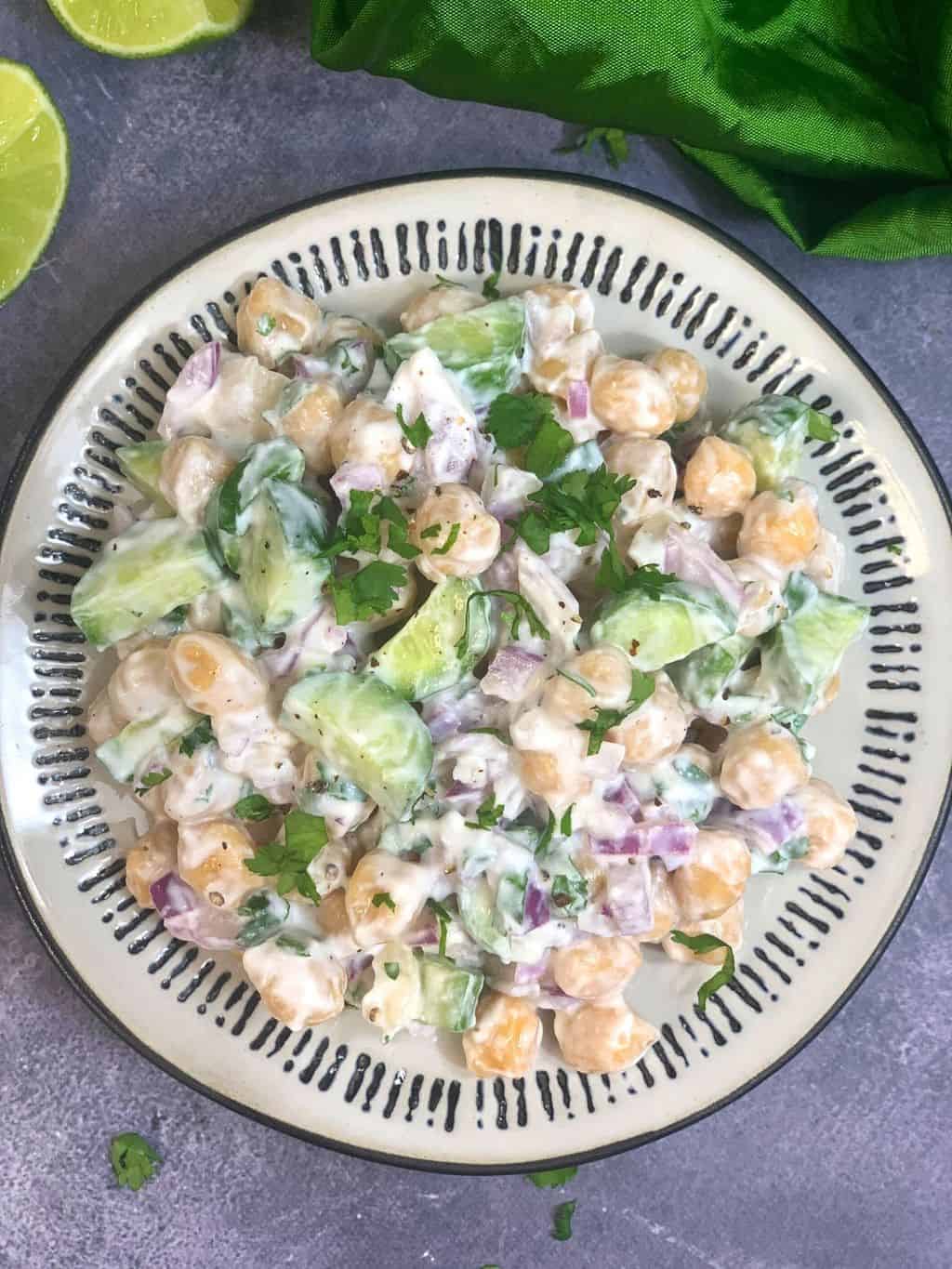 chickpea salad with yogurt dressing served in a plate garnished with cilantro