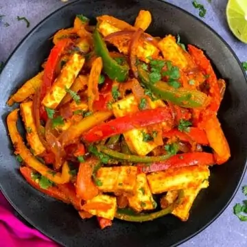 Vegetable Paneer Jalfrezi served in a plate with lemon wedge on the side