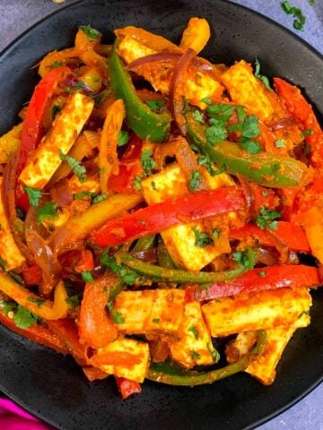 Vegetable Paneer Jalfrezi served in a plate with lemon wedge on the side