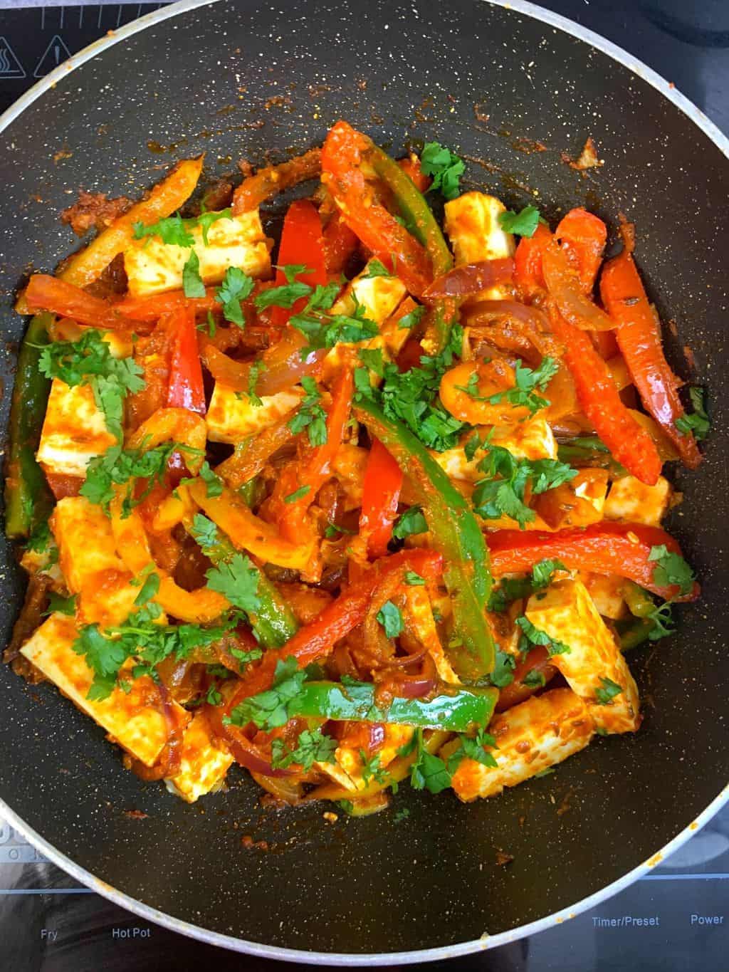 Indian Spiced Cottage Cheese Stir Fry in a kadai garnished with cilantro