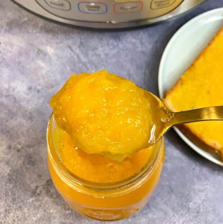 Homemade Pineapple Jam in a glass jar with slice of bread with pineapple jam on side