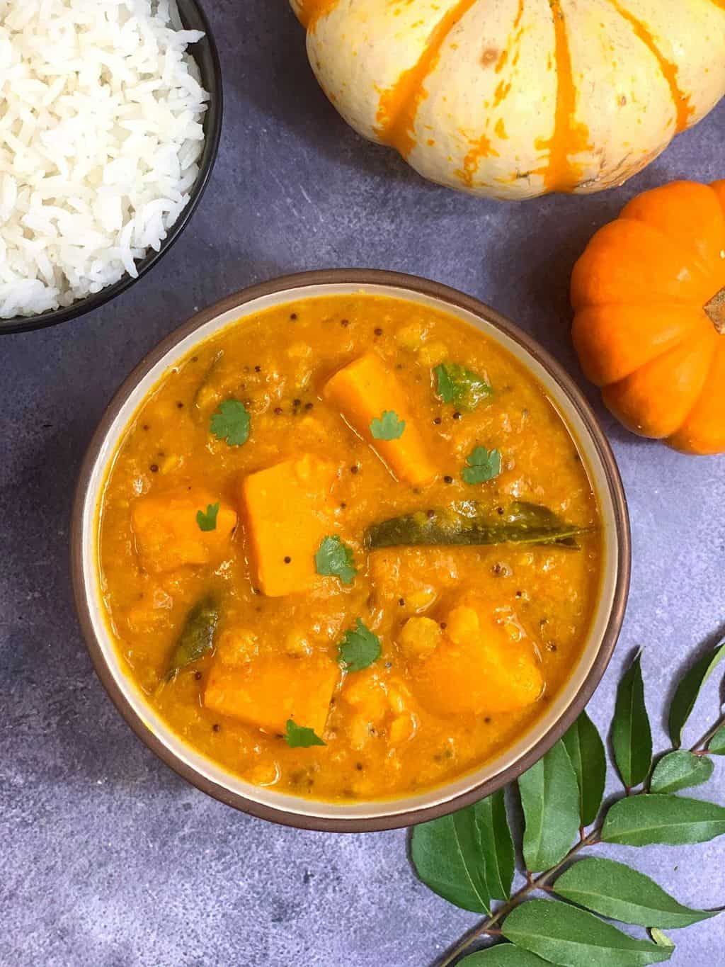 squash lentil stew in a bowl garnished with cilantro with side of steamed rice