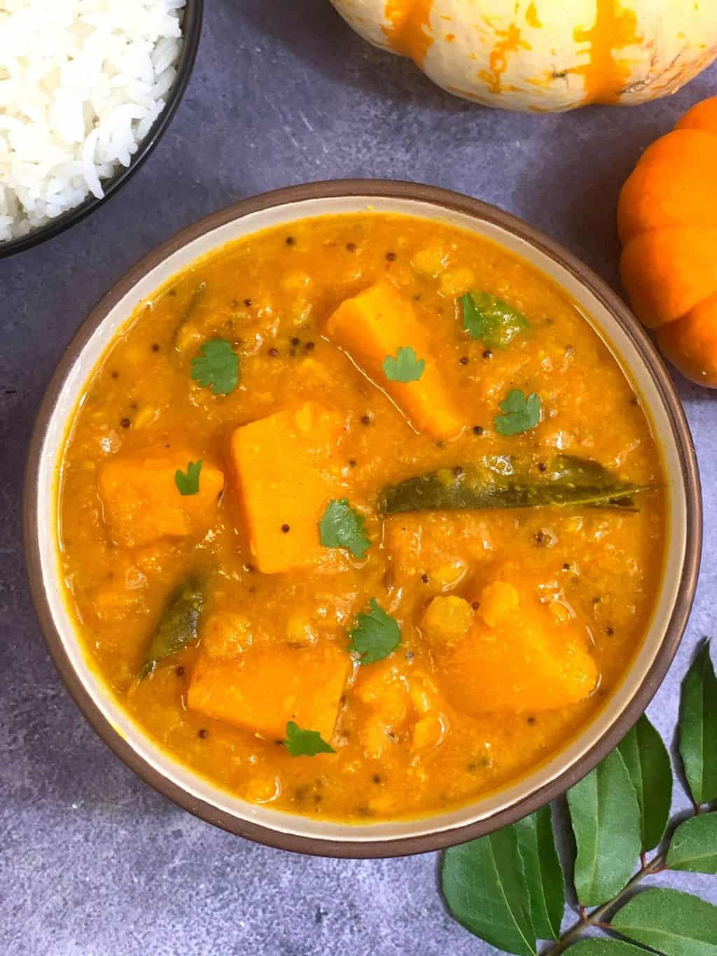 pumpkin sambar served in a bowl with a side of steamed rice 