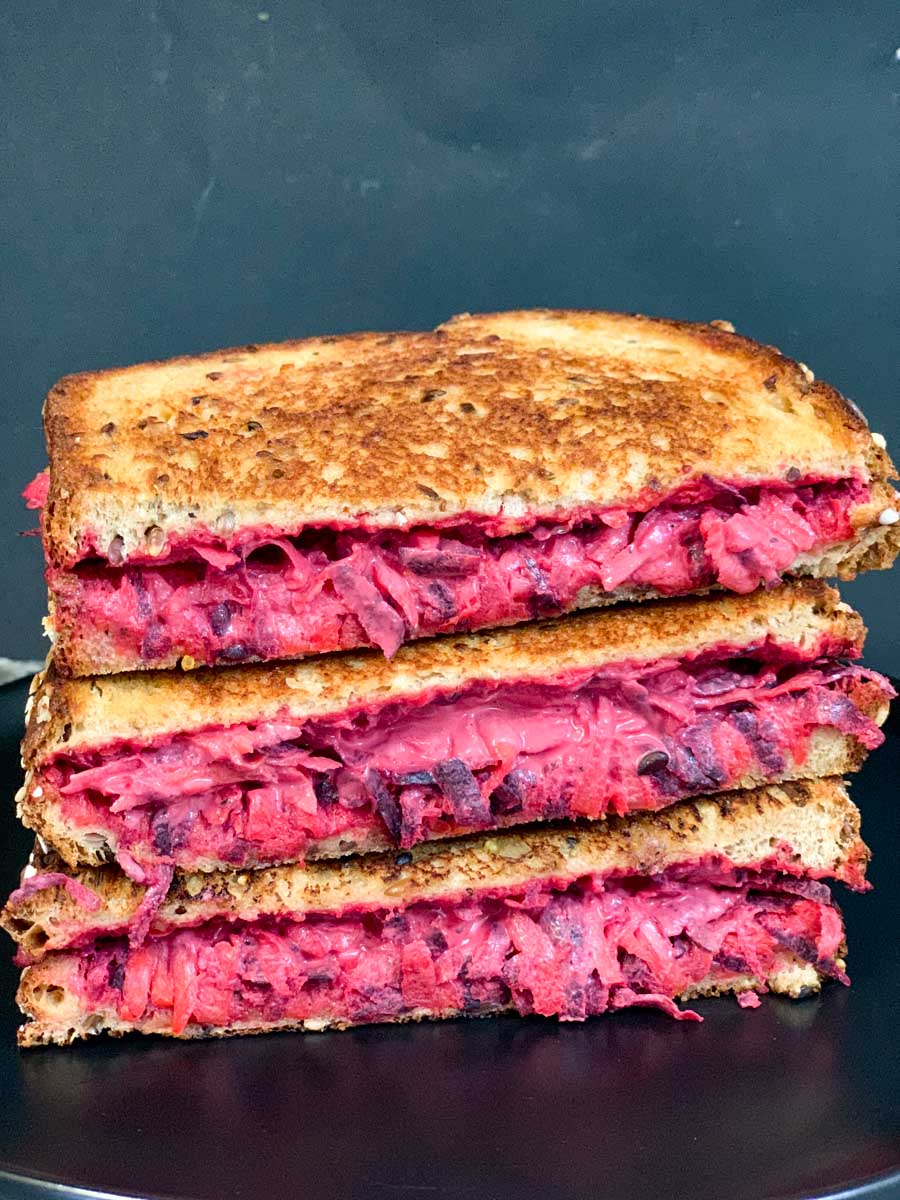 a stack of grilled beetroot carrot sandwich on a plate