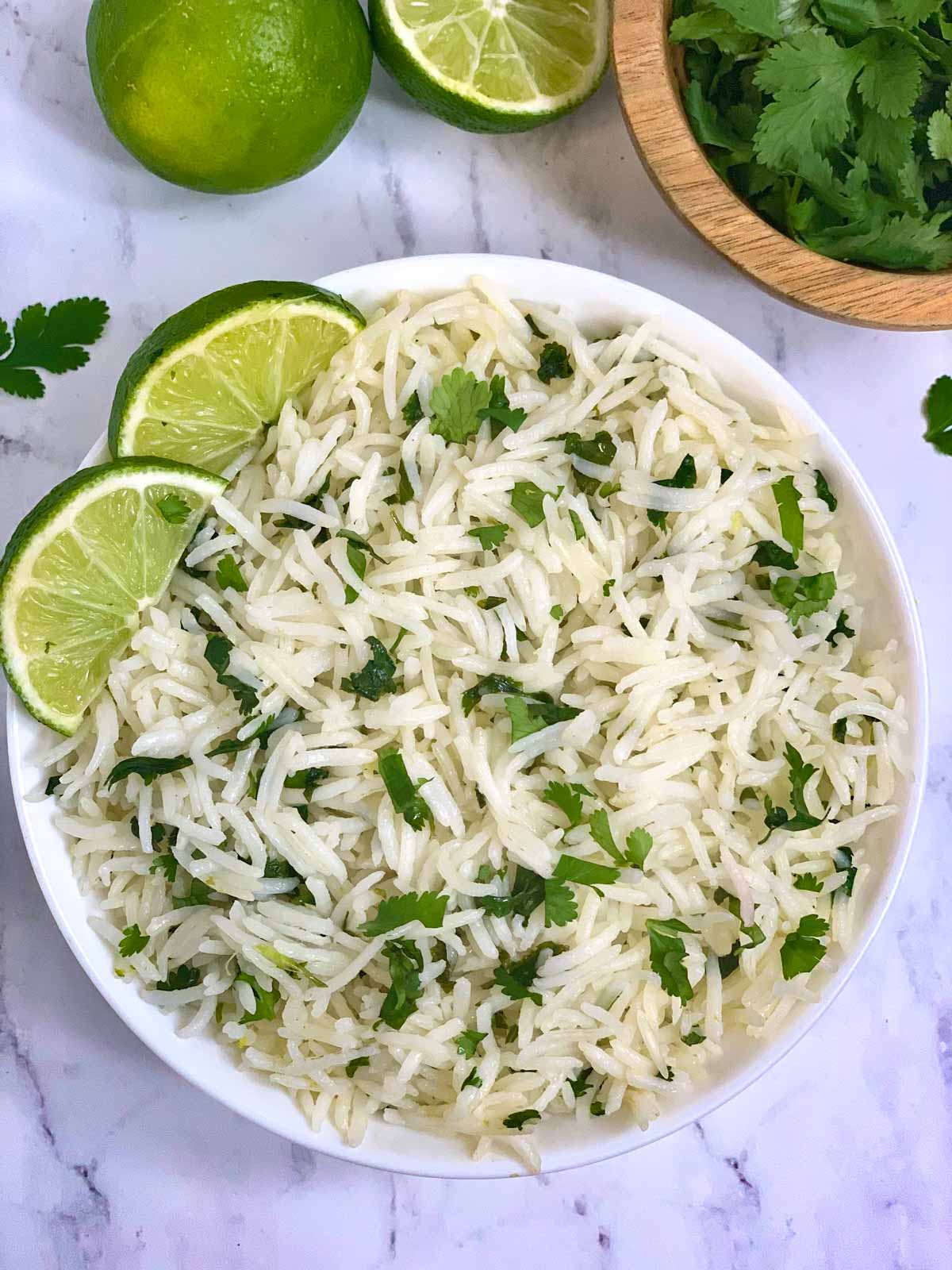 Instant pot cilantro lime rice served in a white bowl with lemon wedges on top