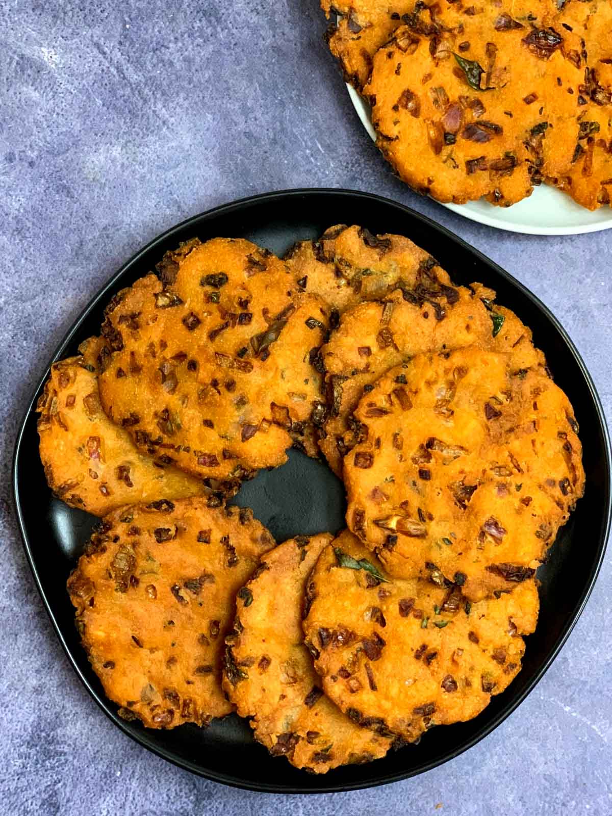 eight to ten maddur vadas placed on a plate in a circular fashion