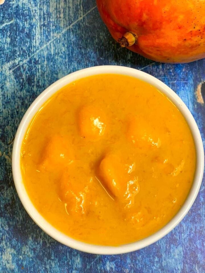 mango rasayana in a bowl with mango on the side