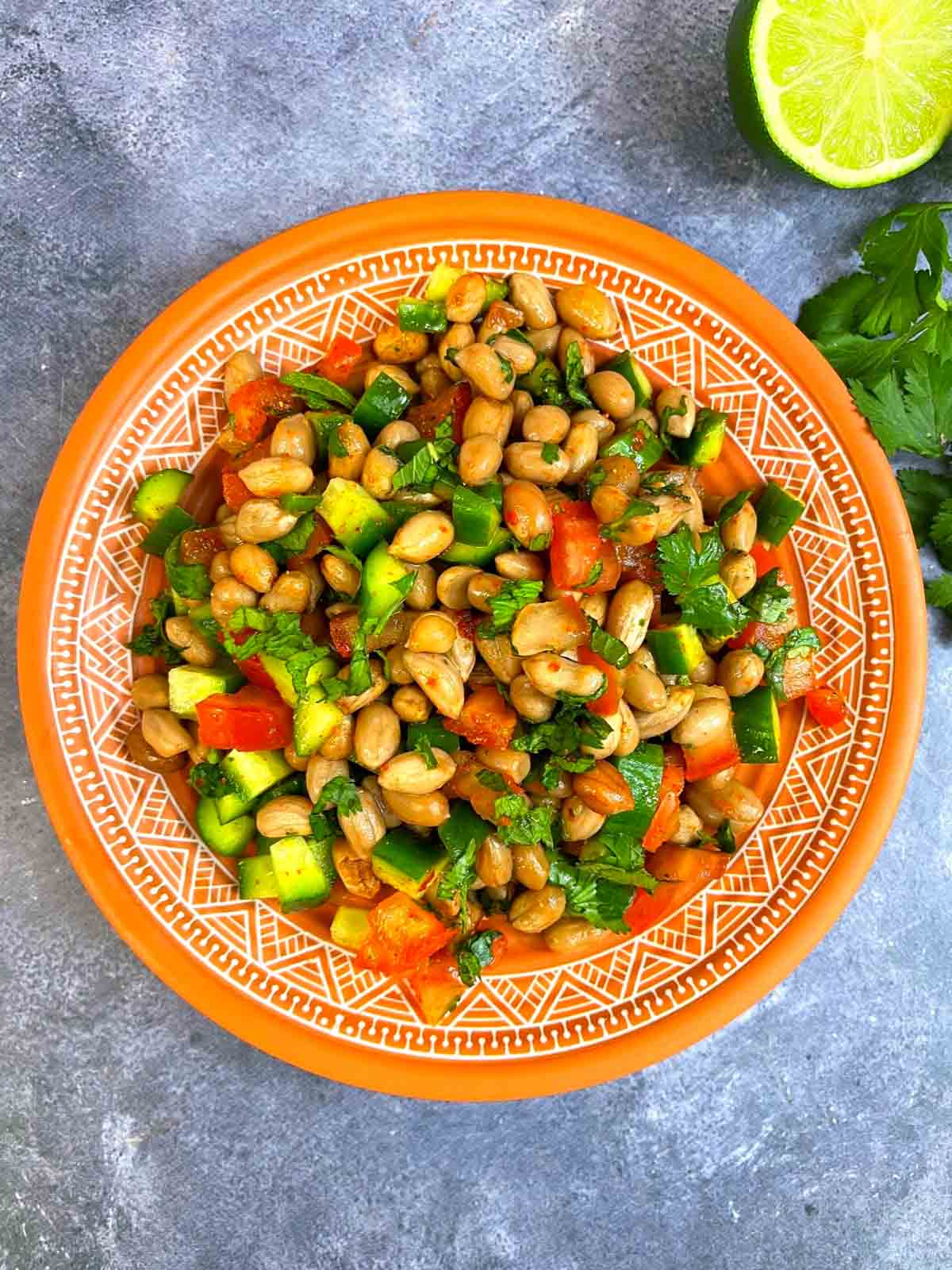 Boiled peanut salad/chaat served on a plate with cilantro and lemon on the side