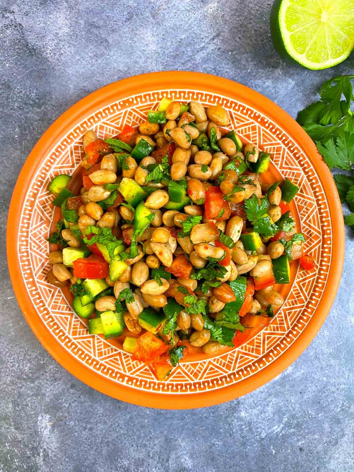 groudnut dish served on a plate with cilantro and lemon on the side